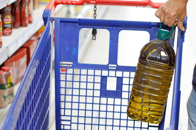 Man buying olive oil in supermarket. Close-up