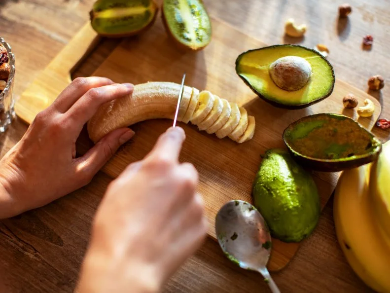 Close up of a young woman making a healthy smoothie at home
