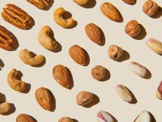Pattern of various nuts on beige. Healthy eating concept. Pecan, brazil nut, almonds, hazelnuts, pistachios, cashews. Top view, flat lay.