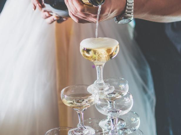 A bride and brideroom holding a bottle of Champagne for celebrate wedding.