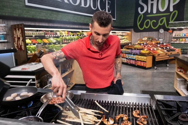 Contestant Carlos Perez grills asparagus and shrimp, as seen on Guy's Grocery Games, Season 28.