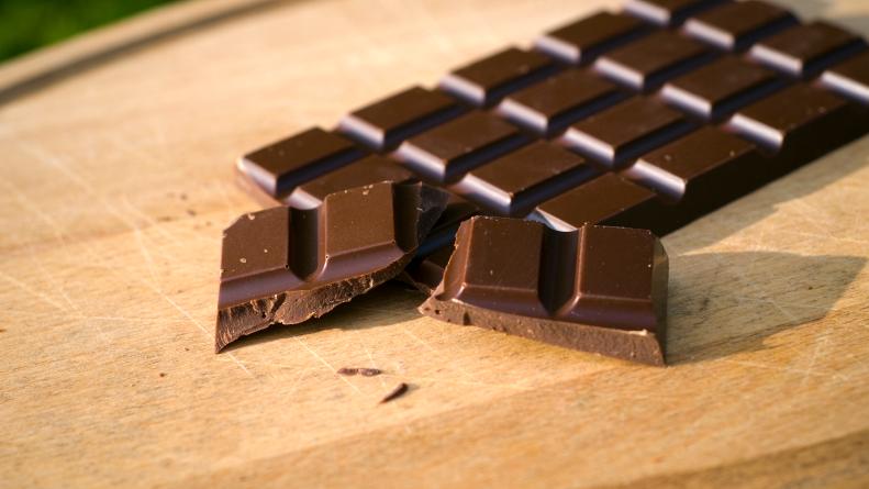 Dark chocolate candy bar on a cutting board. (SEE LIGHTBOXES BELOW for many more desserts, sweet food, baking, & snack photos...)