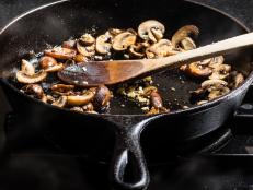 Sauteing sliced mushrooms in a cast iron skillet