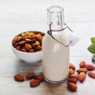 Bottles with almond milk and almonds on the table