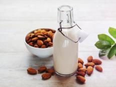 Bottles with almond milk and almonds on the table
