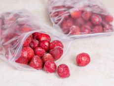 Frozen strawberries in bags, close up. Stocks of meal for the winter.