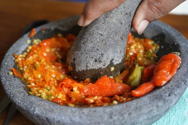Person kneading chili boiled sauce in the kitchen. Preparing Indonesian food.