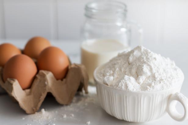 Selective focus of Baking ingredients, flour, egg and milk on white isolated background