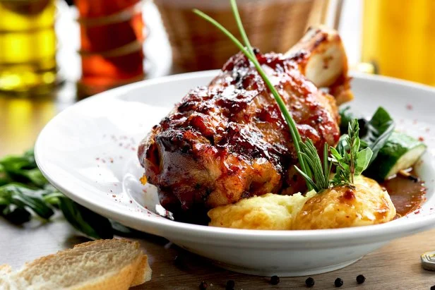 Ham hock in demi-glace sauce baked with cinnamon, aromatic herbs, served with mashed potato. Restaurant food