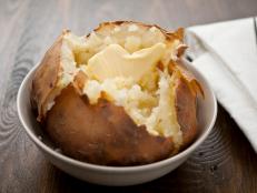Baked potato with melting butter, horizontal.