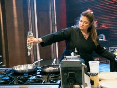 Chef Alex Guarnaschelli pours oil into a pan to cook her dish, as seen on Outchef'd, Season 2.