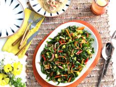 This is not quite a slaw and not a traditional salad; it's plain delicious! A tangy BBQ sauce dressing is the perfect choice to complement the collards, crispy bacon, tart green tomatoes and sweet carrots.