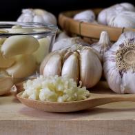 Close-up shot of minced garlic in wooden spoon placed on wooden chopping board In the kitchen prepared for food ingredients.