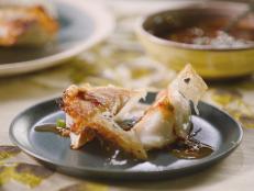 My daughters love making these as a snack or appetizer. Inspired by Japanese hanetsuki gyoza (gyoza with wings) and Chinese binghua jianjiao ("ice-flower fried dumplings"), we tried multiple variations before finding our favorite method. Some restaurants that serve dumplings this way use rice flour to get the crispest, most delicate skirt. Well, we had gluten-free flour on hand, which happens to be rice flour-based. The result, using store-bought frozen dumplings, was just what we were looking for. Be mindful that this skirt is very delicate, so when turning it out, be sure to use a plate that is smaller than your skillet so that it touches the dumplings. We like to serve it with a soy sauce-based dipping sauce that includes fragrant lemongrass and spicy sambal oelek.