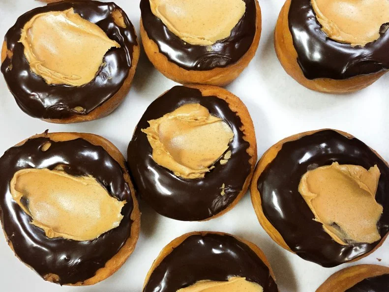 Over-the-Top treat from OHIO. Buckeye Donuts. Regular buckeyes are little chocolaty peanut butter bites. Buckeye Donuts in Columbus supersizes ’em.