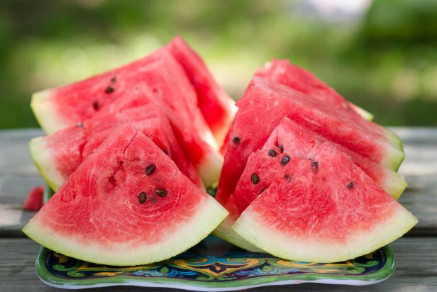 Dallas, TX - June 12, 2015: Freshly cut watermelon slices are displayed on a picnic table outside. The perfect food for a summertime picnic. They are ready to be eaten.