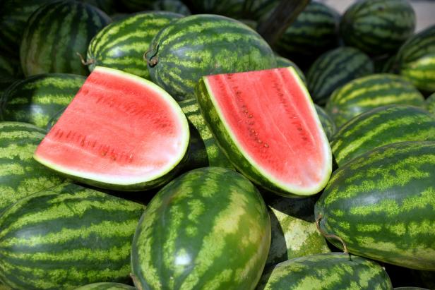 Cut in half of watermelon on watermelon heap in market