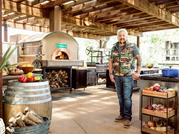 GUY FIERI IN THE OUTDOOR KITCHEN OF HIS CALIFORNIA RANCH.