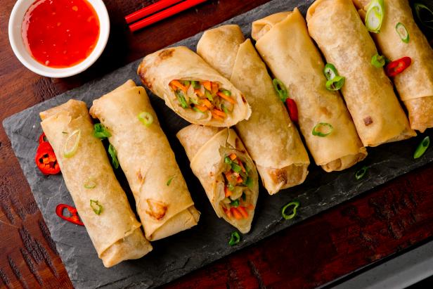 Egg rolls or spring rolls fried.Traditional Chinese Thai restaurant appetizer, spring rolls or egg rolls. Made from wonton wrappers and filled with Chinese veggies and served w/ chili dipping sauce.