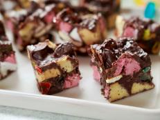 Molly originally made this type of no-bake cake shortly after her second daughter was born. This is her variation of an English Tiffin, which is a no-bake dessert made from prepared ingredients like cookies, nuts, and dried fruit all tossed together then it sets in the fridge. Molly is swapping the dried fruit for gummy worms to get some extra cool mom points!
