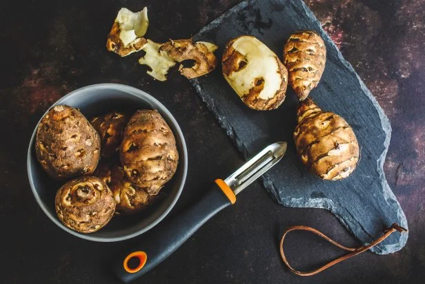 Jerusalem artichokes on rusty background, top view