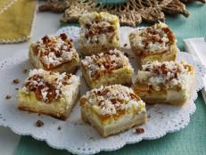 If you're unfamiliar with hummingbird cake, it's a cake spiced with cinnamon and nutmeg; chock-full of mashed banana, pineapple, nuts and coconut; and finished with a cream cheese frosting. I absolutely love hummingbird cake, so I decided to make a bar cookie version using all those flavors. These bars have a spiced shortbread crust and creamy cheesecake filling infused with mashed banana, and are studded with pineapple, coconut and candied pecans on top. I think you're going to love them!