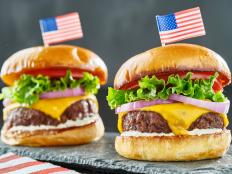 4th of july themed cheeseburgers with mini flags close up