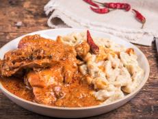 Hungarian chicken stew - chicken paprikash with dumplings, gnocchi on a plate, close-up, rustic style