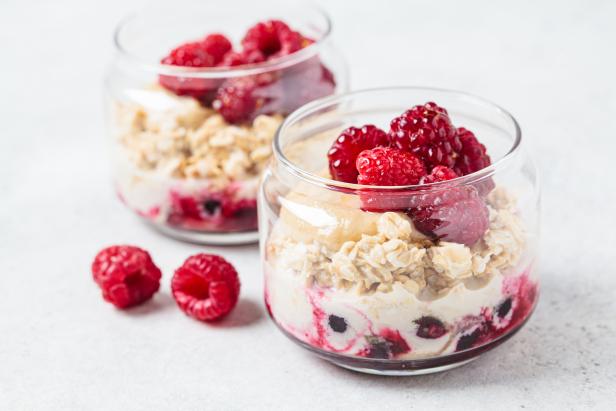 Overnight oatmeal with raspberries, currants and tahini in jar. Healthy breakfast concept.