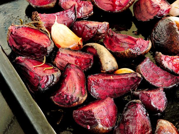 Cooking red beets in the oven. Roasted beets on a baking sheet. Baked beetroot with garlic and spices.