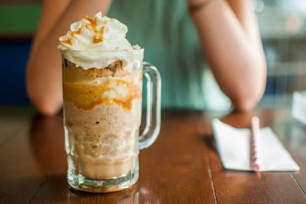 Cold coffee espresso caramel and whipped cream on a dining table