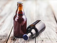 Two brown glass bottles filled with beer are placed on a wooden table.