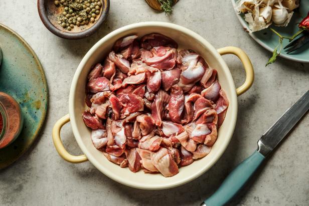 Raw chicken gizzards in cooking pan on kitchen table. Food preparation. Top view