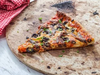 New York style slice of pizza with anchovies and black olives