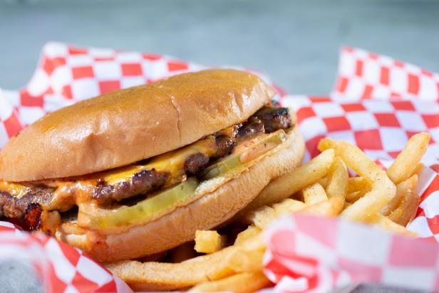 A closeup view of a cheeseburger.