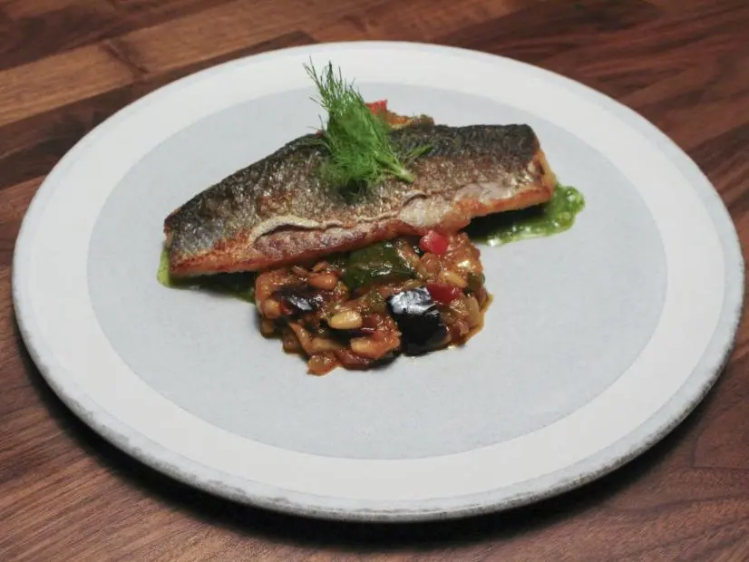 Chef Anne Burrell Main Dish Branzino with Pesto and Egglant Capinata food beauty, as seen on Worst Cooks in America Season 27.