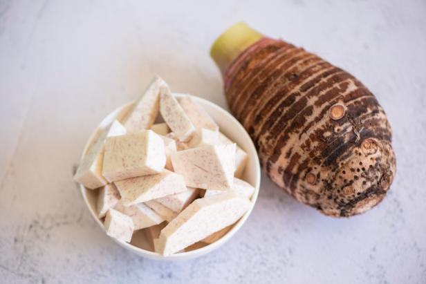 Taro root with slice cubes on bowl and table background, Fresh raw organic taro root ready to cook
