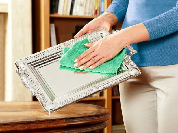 Woman Cleaning Ornate Silver Tray At Home