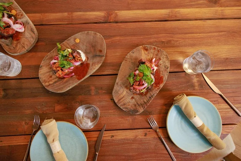 Host Selena Gomez and Chef Stephanie Izard's dish "Skirt Steak Toast", as seen on Selena + Restaurant, Season 1.