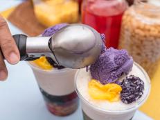 Adding a scoop of ube ice cream to top a recipe of Halo-halo, a popular cold dessert in the Philippines.