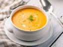 Close up of soup made with carrot and cream and croutons