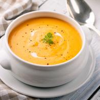 Close up of soup made with carrot and cream and croutons