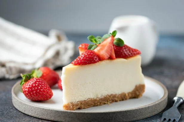 Slice of strawberry cheesecake with graham cracker crust on plate. Classical new york cheesecake