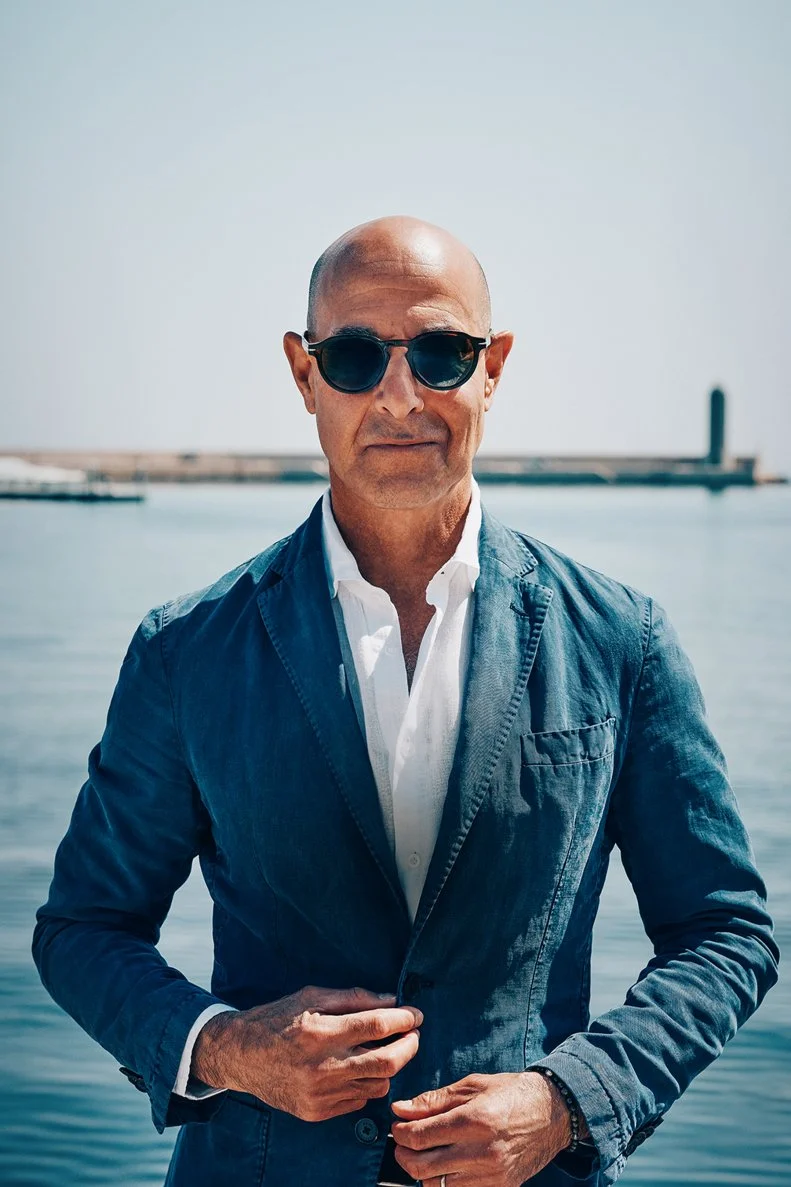 Stanley Tucci posing in front of the ocean for his show, Searching for Italy