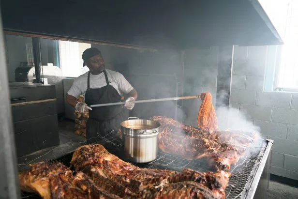 Rodney Scott mops BBQ sauce on a whole hog