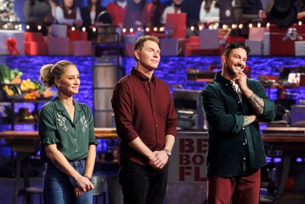 Contender Brooke Williamson, chef Bobby Flay, and contender Gabriele Bertaccini await the results of Round 2, as seen on Beat Bobby Flay Holiday Throwdown, Season 4.