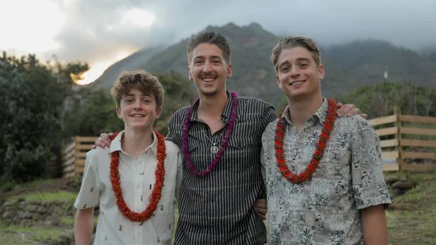 The Fieri Family posing at the Luau at Noho'ana Farms in Wailuku, Hawaii, with mountains in the background, as seen on Guy's Hawaiian Eats, Episode 1.