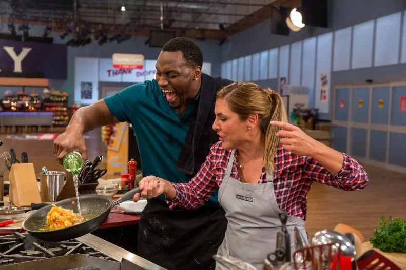 Pro Athlete Takeo Spikes and Celebrity Chef Lorena Garcia prepare their dish during Game 1, Express Lane, as seen on Food Network's Guy's Grocery Games, Season 7.