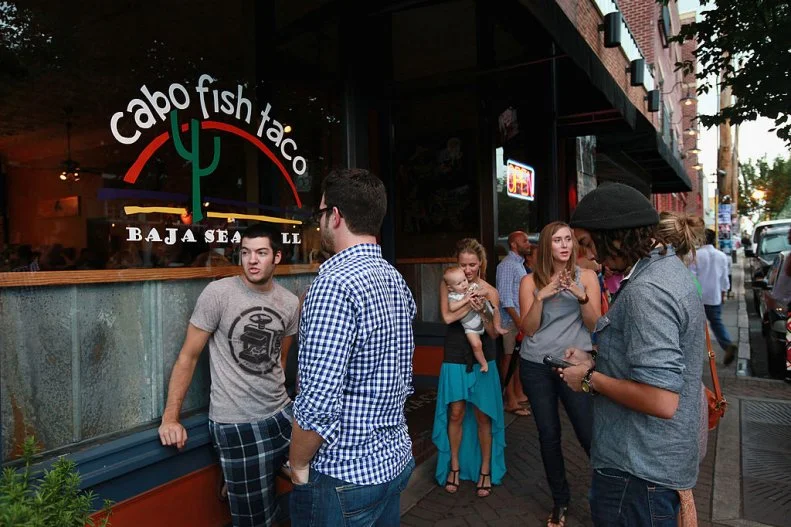 CHARLOTTE, NC - JULY 11:  Customers wait for an available table outside Cabo Fish Taco restaurant on July 11, 2012 in Charlotte, North Carolina. Cabo Fish Taco is located in NoDa, Charlotteâ  s historic arts district known for its galleries, performance venues and funky restaurants. Businesses in Charlotte are anticipating a boost in sales when the city hosts the 2012 Democratic National Convention (DNC) September 3-6.  (Photo by Scott Olson/Getty Images)