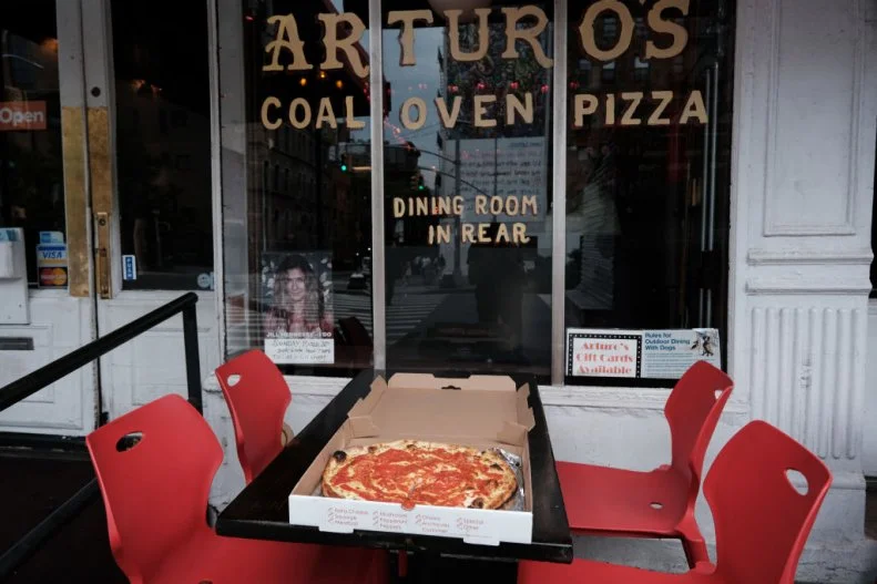 NEW YORK, NEW YORK - JUNE 26: Pizza from Arturo's, a famed New York City restaurant that makes coal oven pizzas, sits on a table outside of the restaurant on June 26, 2023 in New York City. The New York City Department of Environmental Protection (DEP) has proposed new rules that would would require pizzerias with coal and wooden-fire ovens installed prior to 2016 to cut carbon emissions by 75%. The DEP has stated that wood and coal-fired stoves are among the largest contributors of harmful pollutants in neighborhoods with poor air quality. Restaurants with the stoves would be forced to install emission-control air-filter devices. (Photo by Spencer Platt/Getty Images)